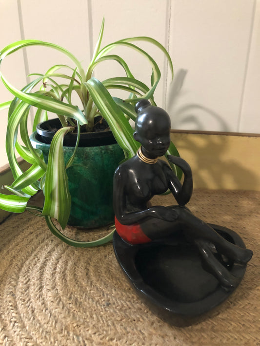 Tribal lady sitting on ashtray. Black